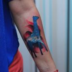 Watercolor giraffe tattoo on the forearm