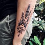Wave in a rhombus and wild plants tattoo