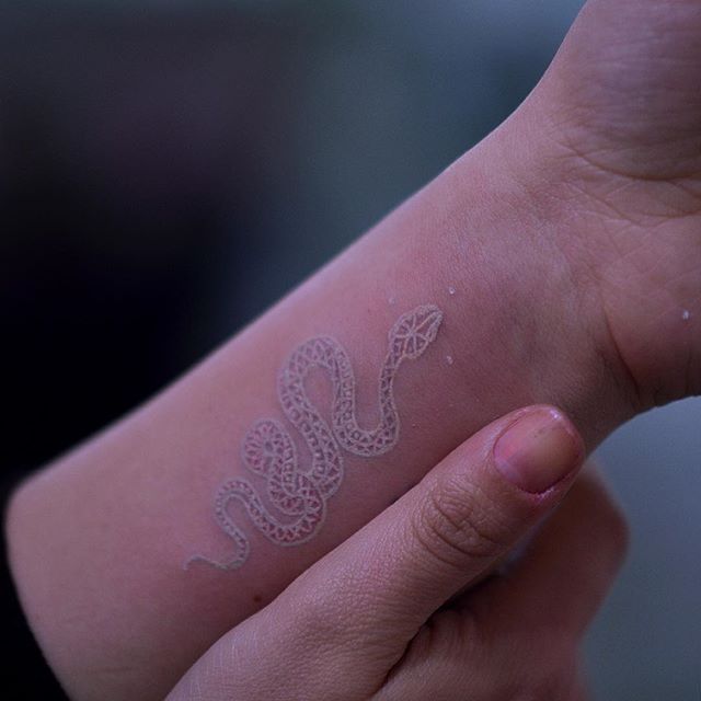 White snake tattoo on the wrist