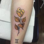Yellow rose tattoo on the calf