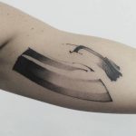Abstract black tattoo on the left bicep