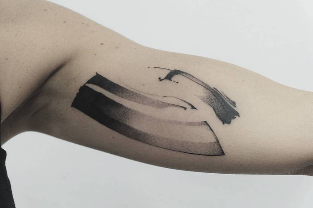 Abstract black tattoo on the left bicep