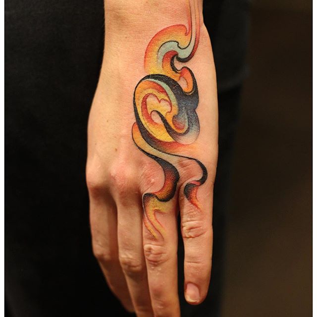 Abstract colorful smoke tattoo on the hand