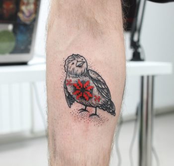 Bird with a red ornament tattoo