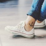 Black anchor tattoo on the right inner ankle