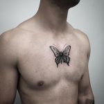 Black butterfly tattoo on chest