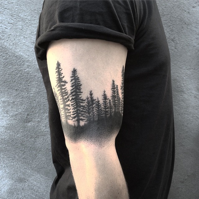 Black forest bicep tattoo