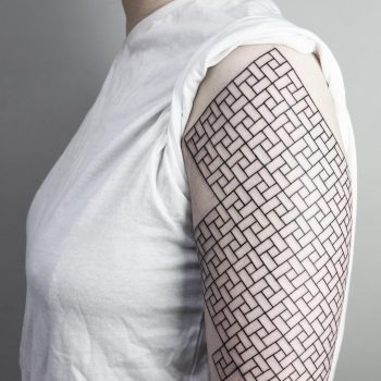 Black geometric pattern tattoo on the left arm