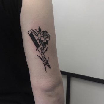 Black knife and rose tattoo