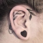 Black leaf tattoo on the ear