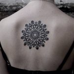 Black ornamental mandala tattoo on the back