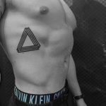 Black penrose triangle tattoo on the rib