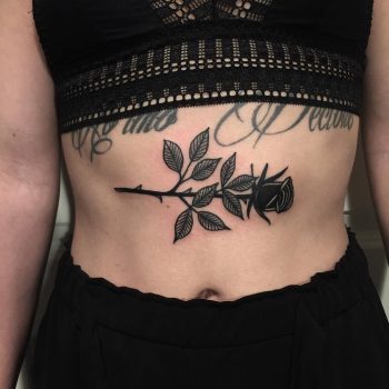 Black rose tattoo on the sternum