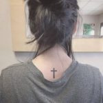 Black small cross tattoo on the back