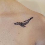 Black tattoo of a whale