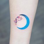 Blue crescent moon tattoo