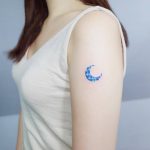 Colorful crescent moon tattoo on the arm