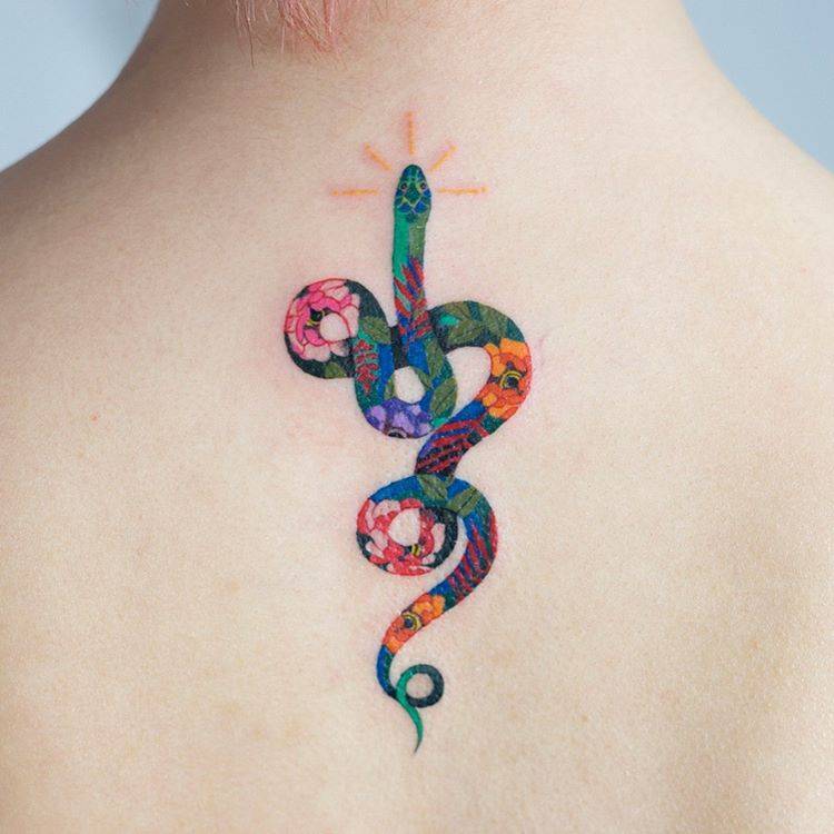 Colorful floral snake tattoo on the upper back
