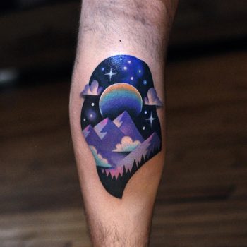 Colorful mountainous landscape tattoo on the calf