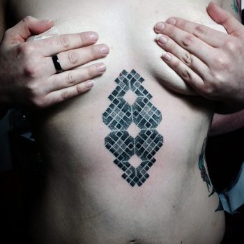 Geometric pattern tattoo on the sternum