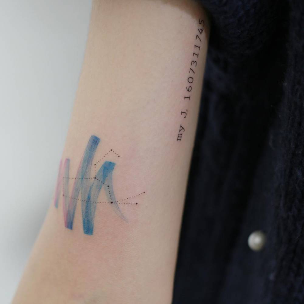 Leo constellation and watercolor paintbrush stroke tattoo