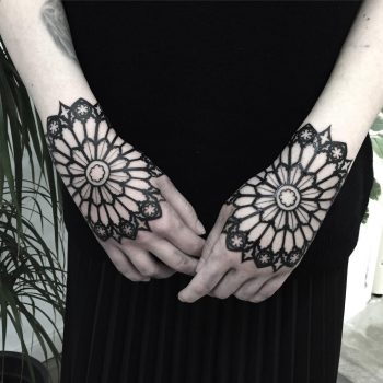 Matching black mandala tattoos on the hands