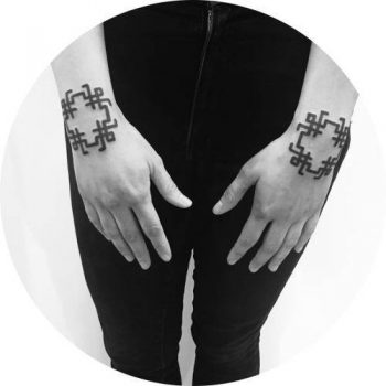 Matching black ornament tattoos on both hands