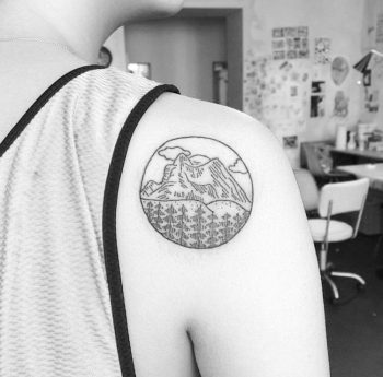 Minimalist mountainous landscape tattoo on the right shoulder blade