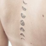 Moon phases tattoo on the spine