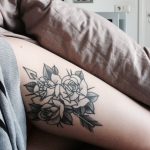 Outline black roses tattoo on the left thigh