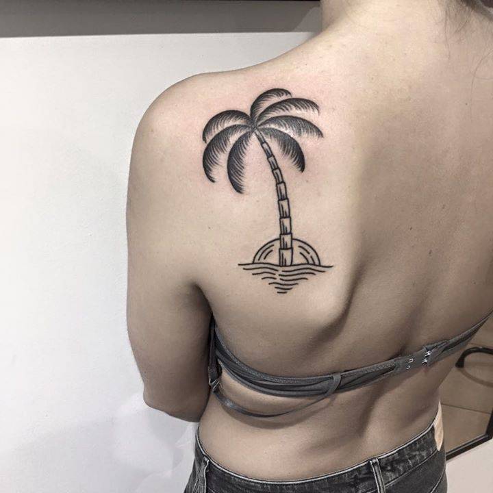 Palm tree tattoo on the left shoulder blade