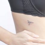 Paper plane rib tattoo