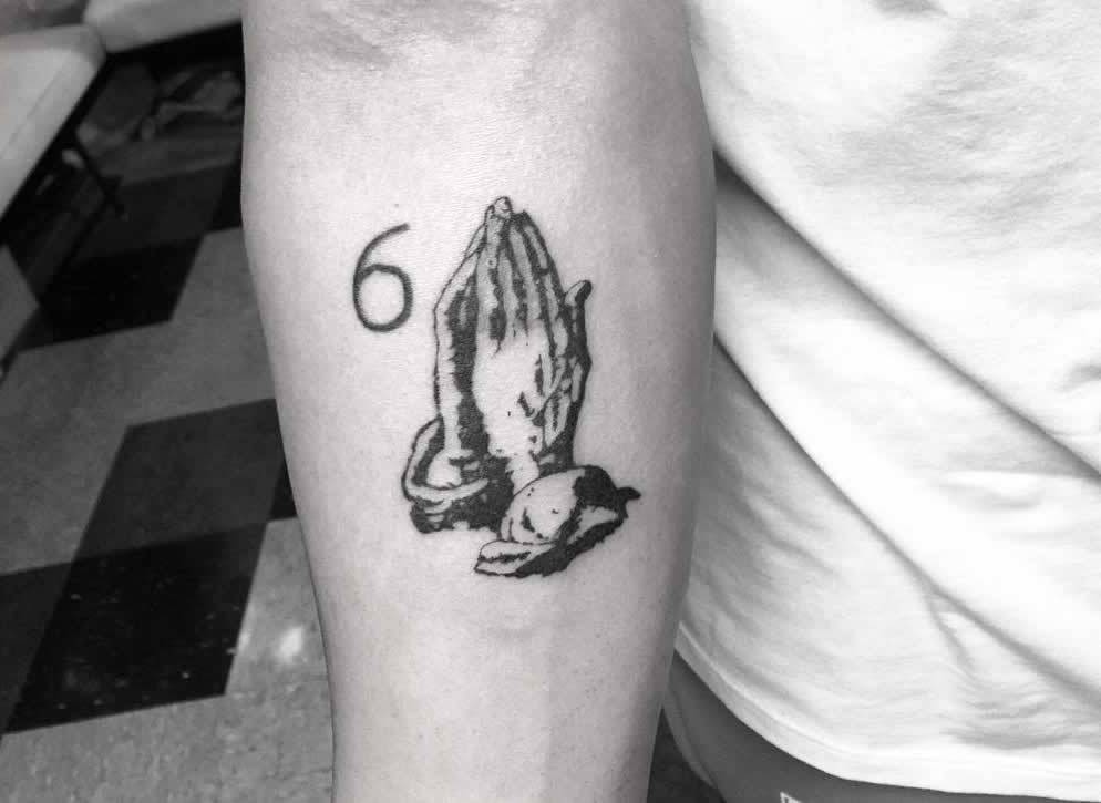 Praying hands and number 6 tattoo