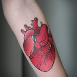 Red heart tattoo on the forearm