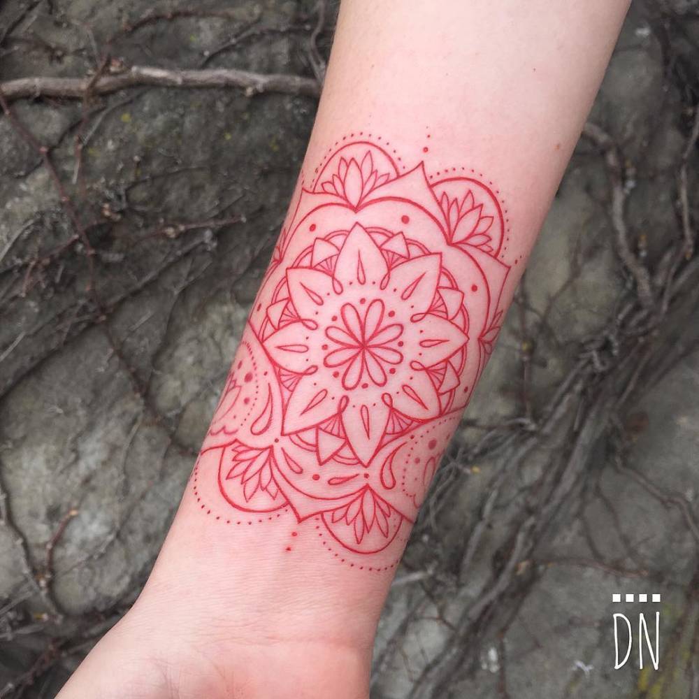 Red mandala tattoo on the inner wrist