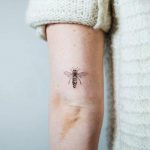 Small bee tattoo on the back of the arm