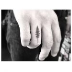 Small pine tree tattoo on the ring finger
