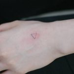 Small triangle tattoo on the left hand