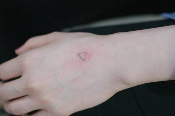 Small triangle tattoo on the left hand