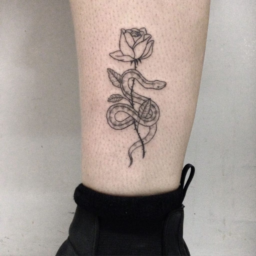 Snake wrapped around a rose tattoo