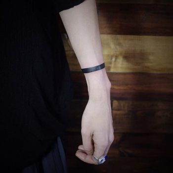 Solid black wristband tattoo
