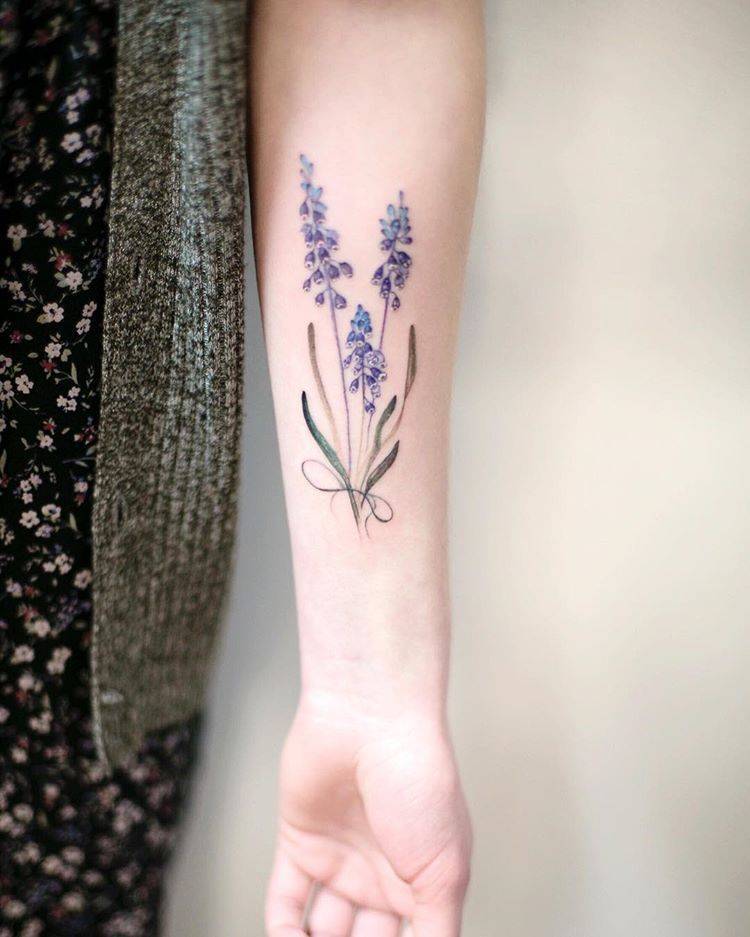 Subtle lavender tattoo on the left inner forearm