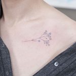Subtle tiny branch tattoo on the collarbone
