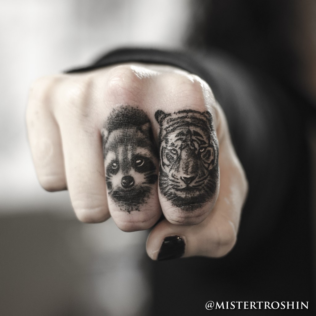 Tiger and raccoon tattoos on fingers