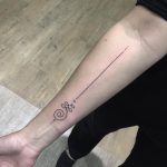 Unalome and black long line tattoo on the forearm