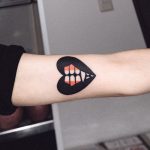 Vampire teeth tattoo on the arm