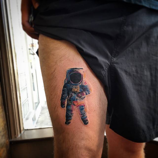 Watercolor astronaut tattoo on the thigh