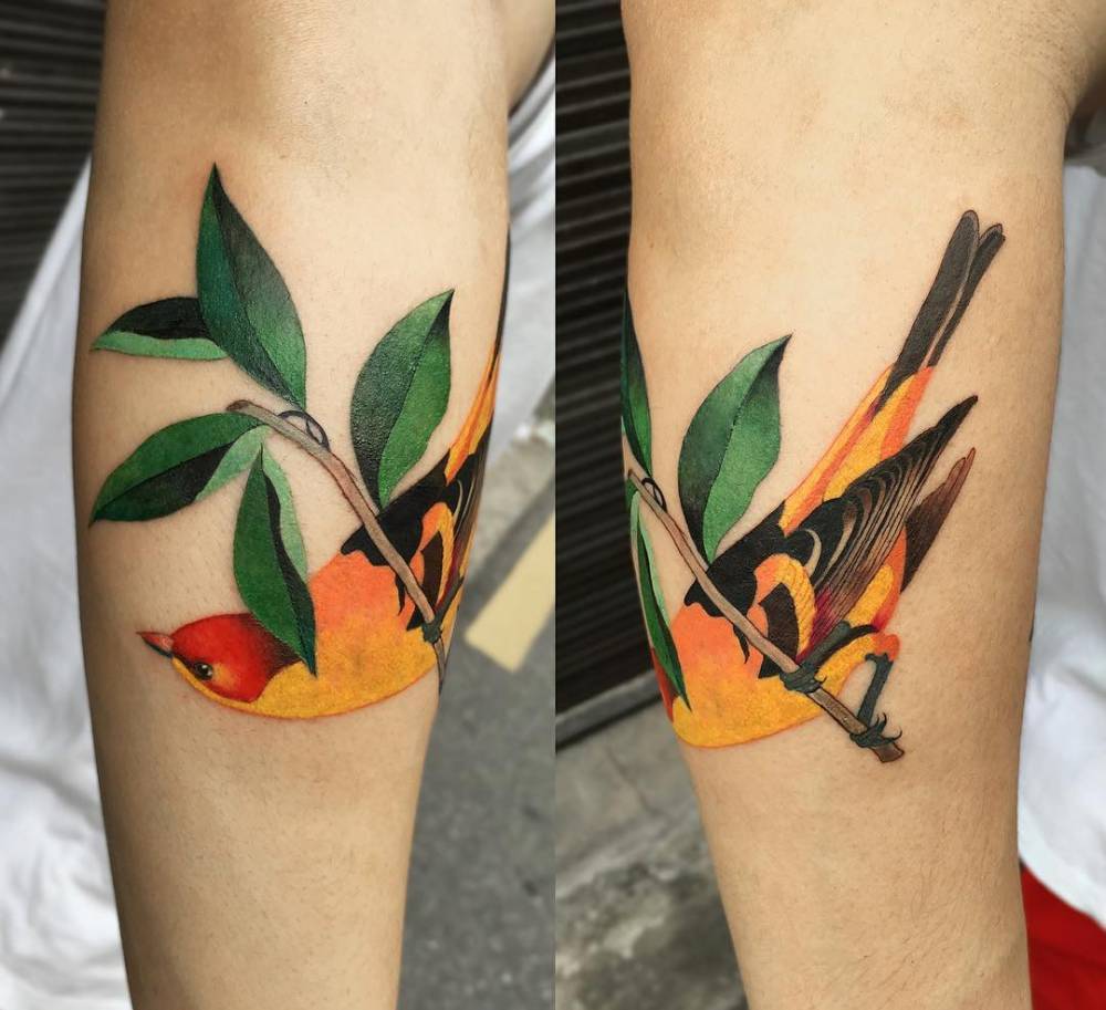 Watercolor bird tattoo on the forearm