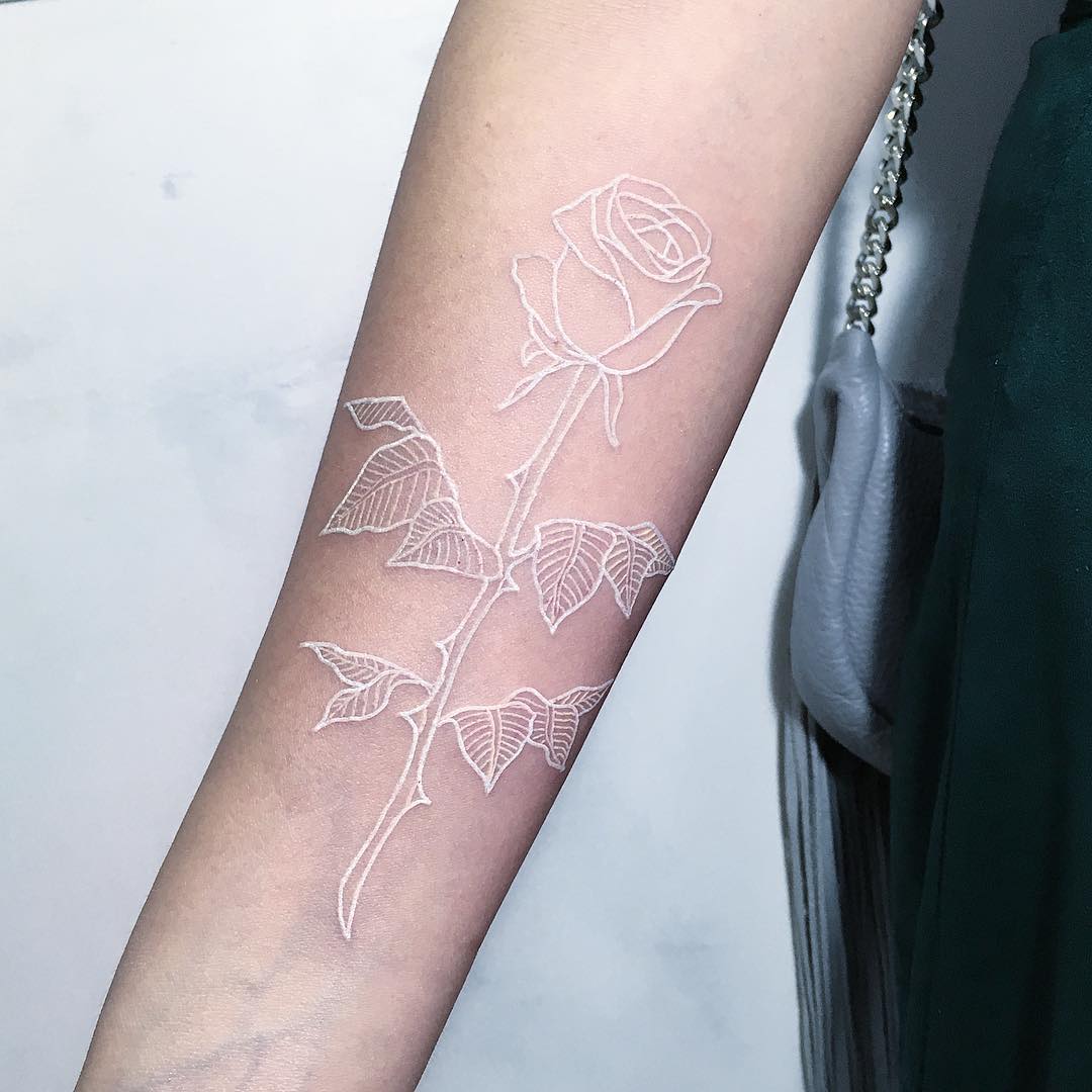 White outline rose tattoo