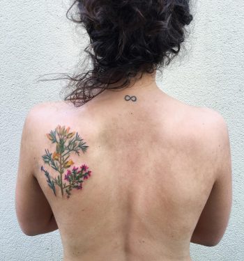 Wildflower tattoo on the left shoulder blade